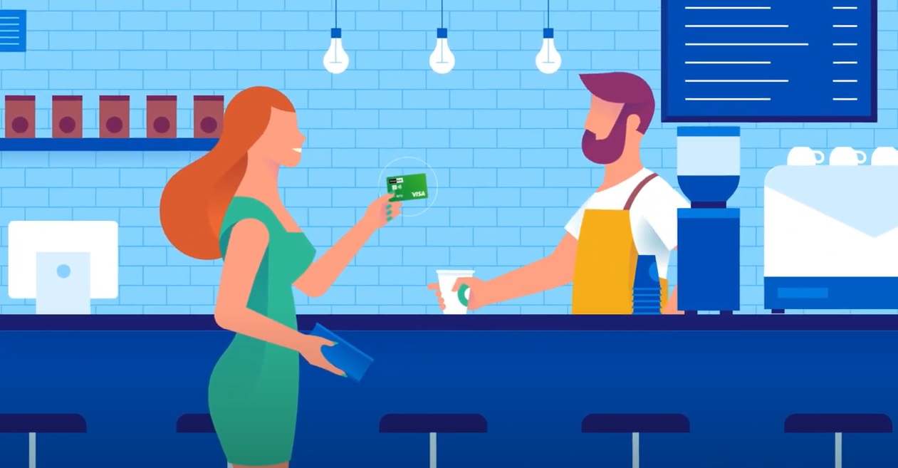 Mujer pagando con su tarjeta en un cafe